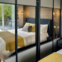 Lakewood Lodge double bedroom - Bed and view of decking reflected in Mirrors of wardrobe