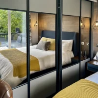 Lakewood Lodge double bedroom - Bed and view of decking reflected in Mirrors of wardrobe